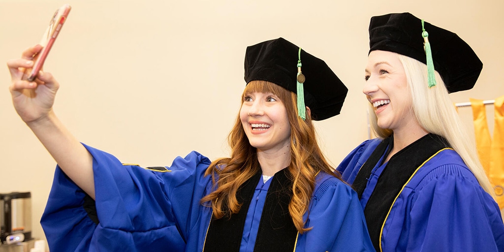 Two graduates take a selfie before Commencement at Mayo Clinic in Florida