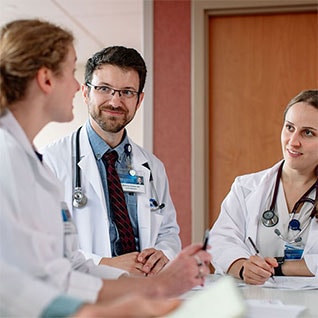 Three Mayo Clinic physicians discuss at a table