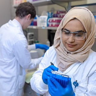 A research trainee records information on a handheld device