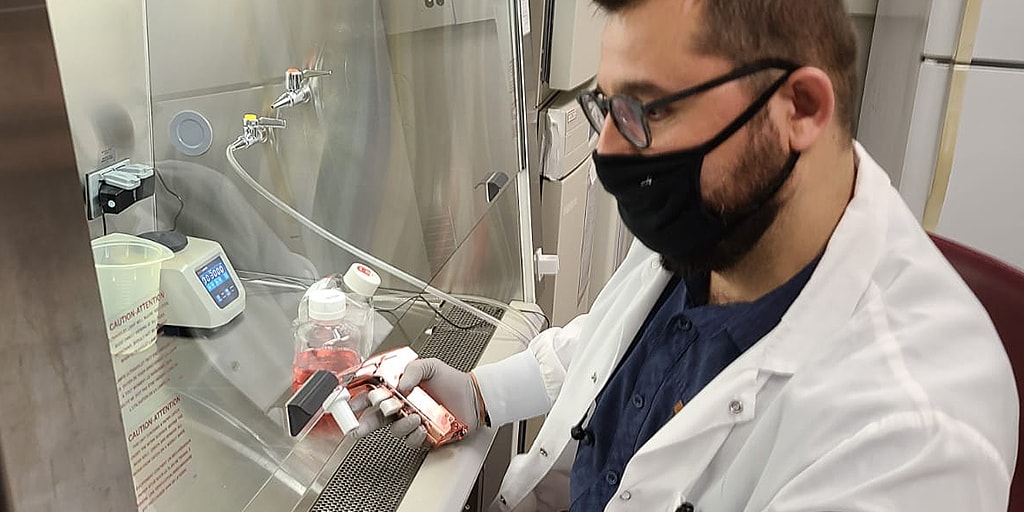 Ismail Can, Ph.D. student using a pipette under the hood in his research lab