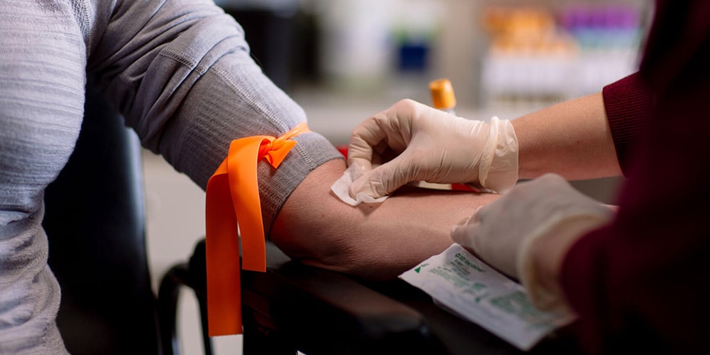 Mayo Clinic phlebotomy technician draws blood from a patient in the clinic
