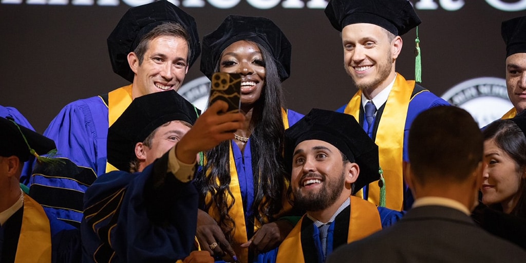 Graduates at commencement in Arizona take a selfie on stage