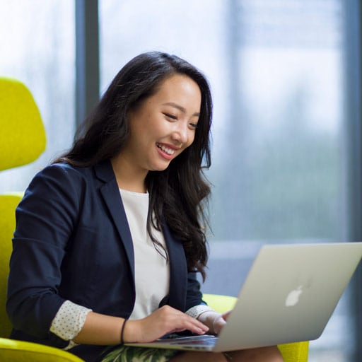 Girl sitting at chair smiling at computer during a Virtual Visit