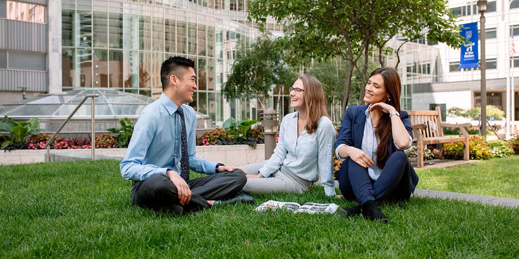 Three students sitting on the lawn at Mayo Clinic's campus in Rochester, Minnesota