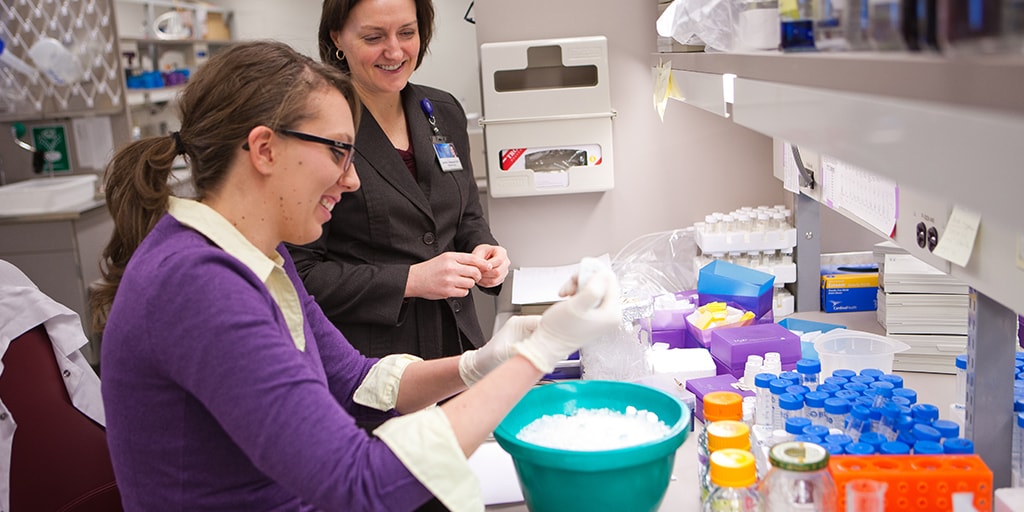 Girl with mentor in research lab working with cold baths at the bench