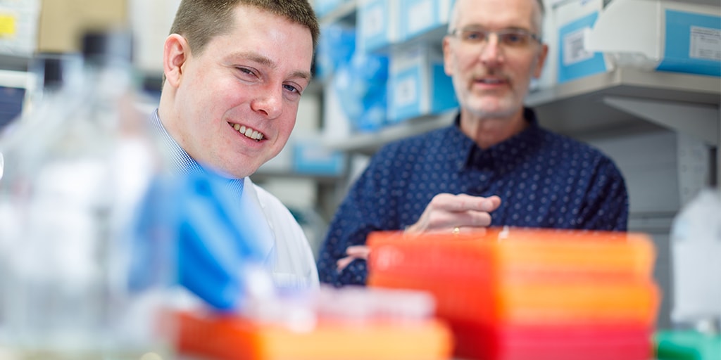 Student and mentor in research lab with sample