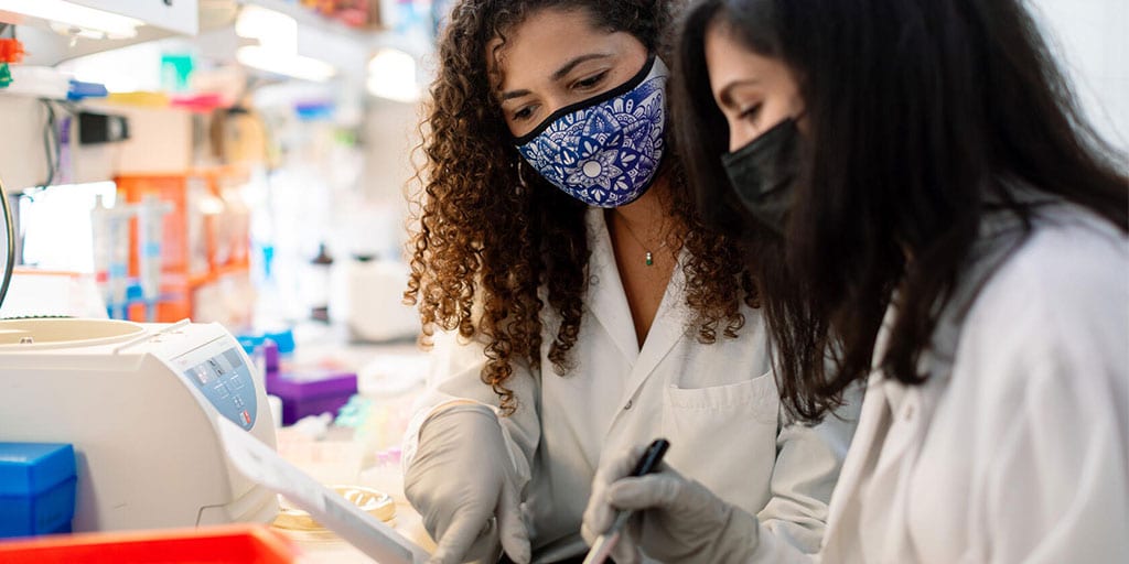 Mentor and student in a lab setting reviewing a document