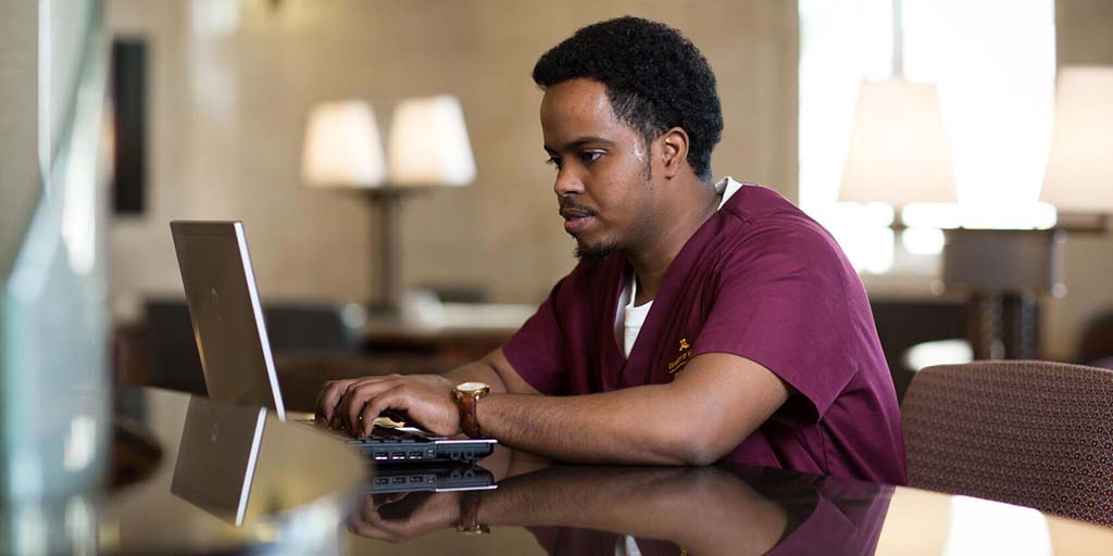 Student on a computer working in the library