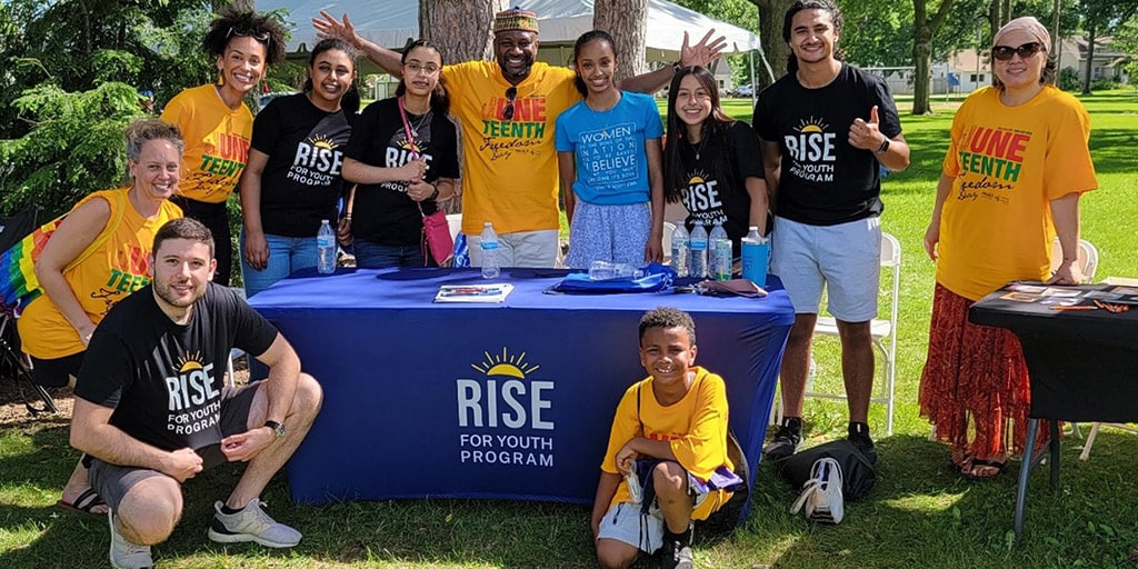 RISE for Youth students and mentors gather together for a group photo outside.