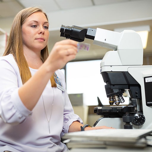 Mayo Clinic cytotechnology student preparing a specimen slide under a microscope