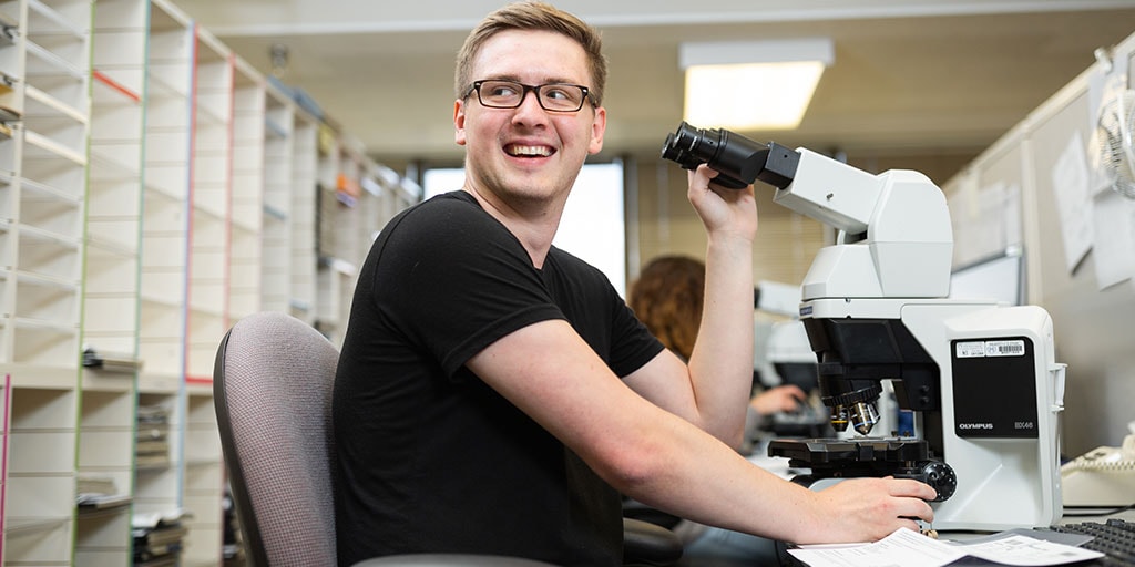 Mayo Clinic cytotechnology student reviewing specimens using a microscope