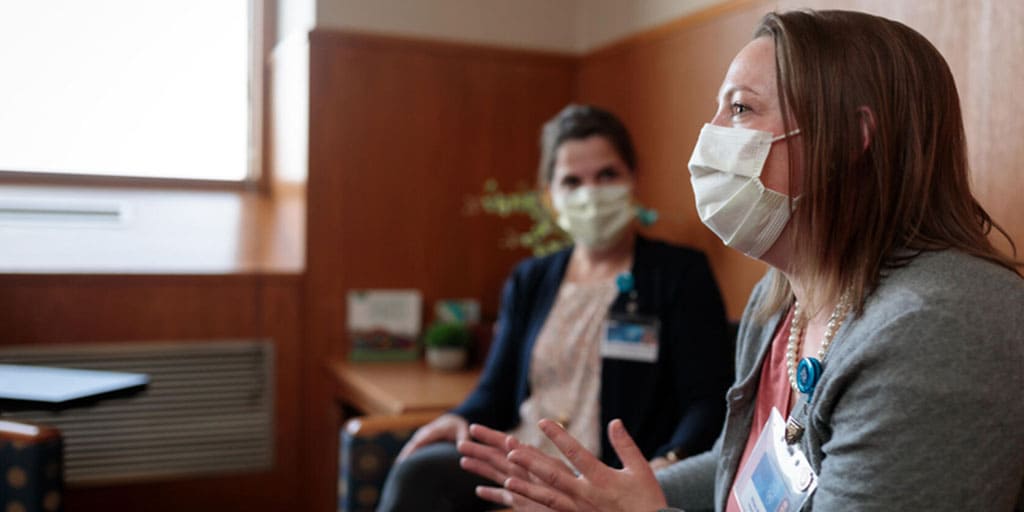 Two people sitting in a doctor's office talking