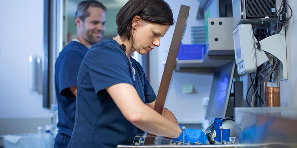 Nuclear medicine technologist reviewing something on a lab bench