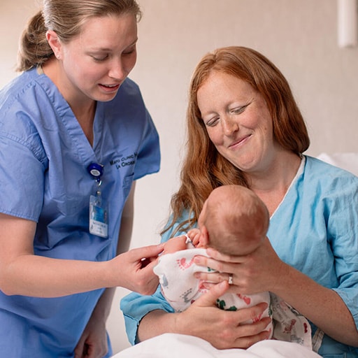 Nurse midwife examines a mom and newborn patient