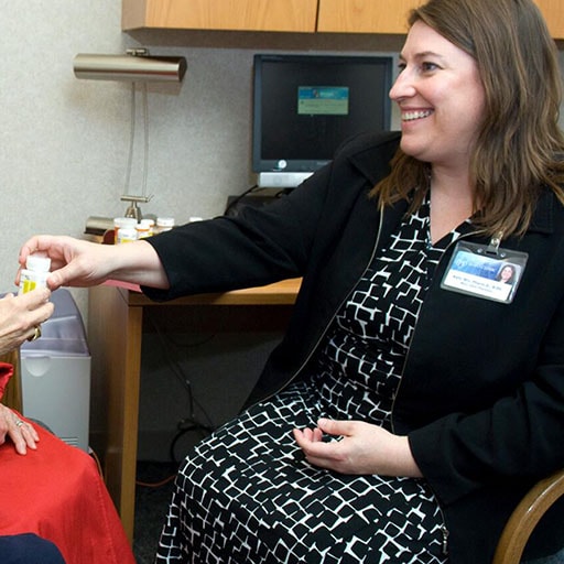 Pharmacist Kelly Wix meets with an elderly patient and her son