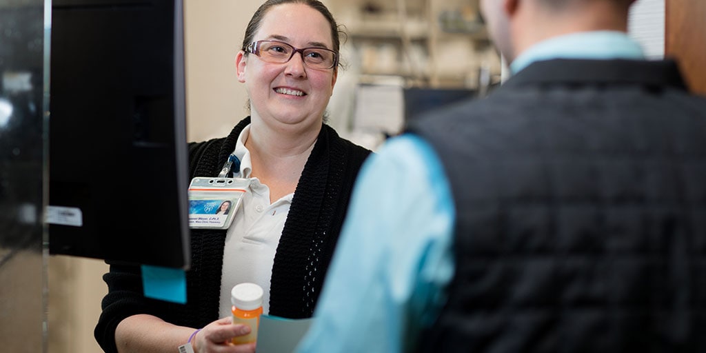 Pharmacy technician reviewing a prescription with a patient