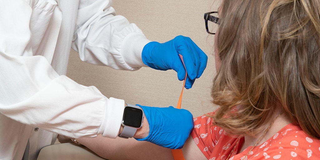 A Mayo Clinic phlebotomist technician working with a patient