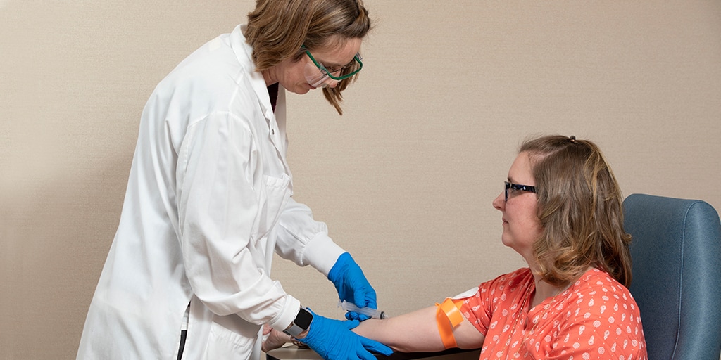 A Mayo Clinic phlebotomist technician working with a patient