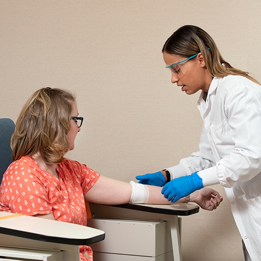 A Mayo Clinic phlebotomist technician working with a patient