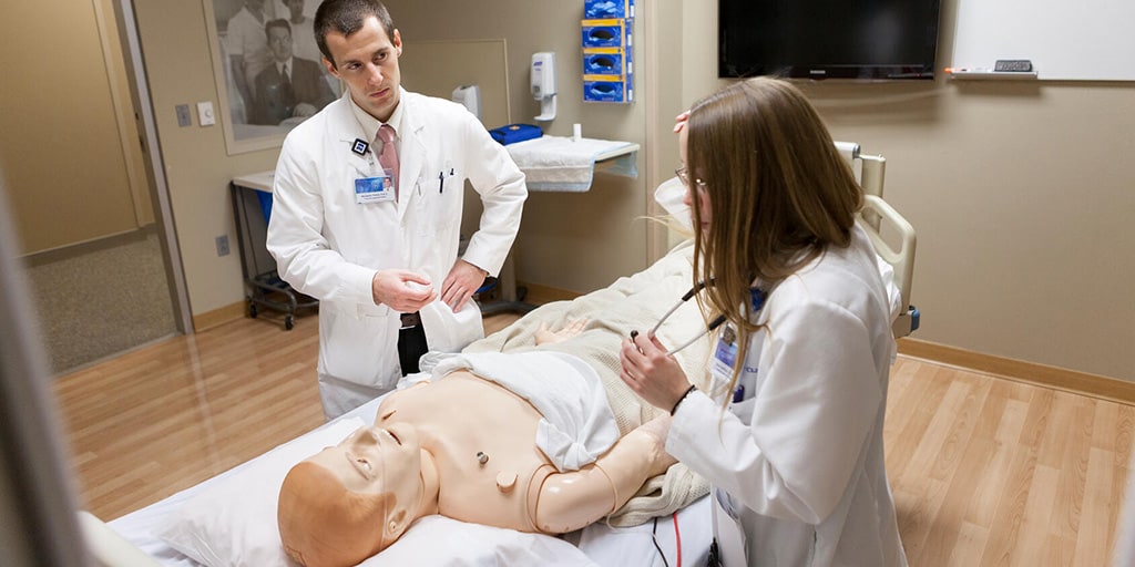 Physician assistants in hospital internal medicine examine a patient in a simulated situation