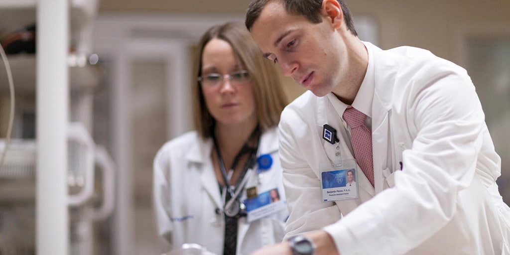 Physician assistants in hospital internal medicine examine a patient in a simulated situation