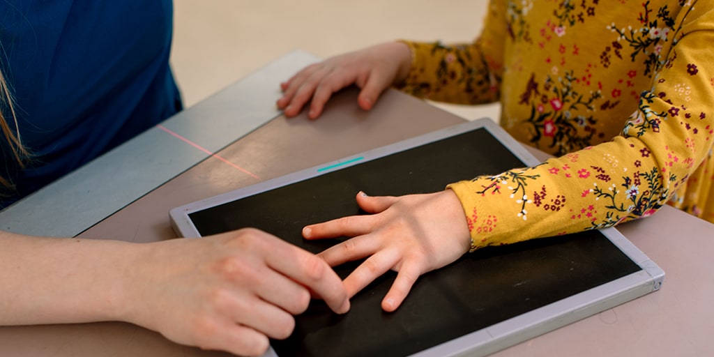 Radiography student performing a hand exam on a small child's hand