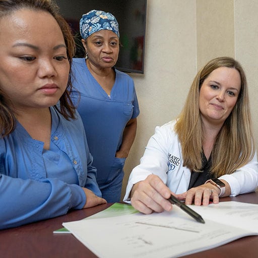 Endocrinology nurse practitioners and nurses confer over patient treatment plans in a meeting room at Mayo Clinic