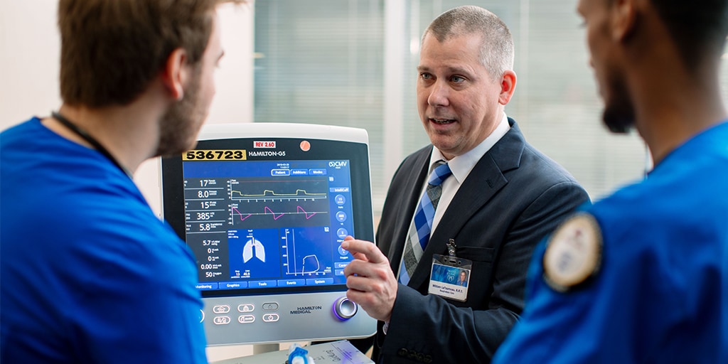 Faculty and students reviewing computer screen with respiratory care results
