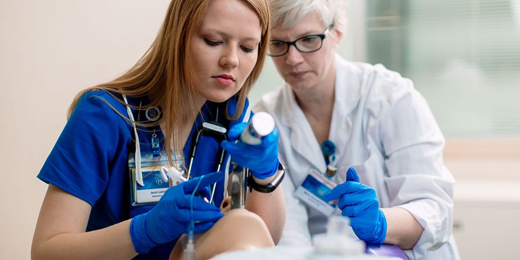 Mayo Clinic respiratory therapy student practicing a procedure with a mannequin with a faculty member supervising