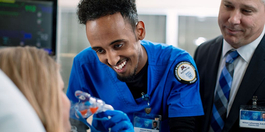 Mayo Clinic respiratory therapy student placing a mask on a patient