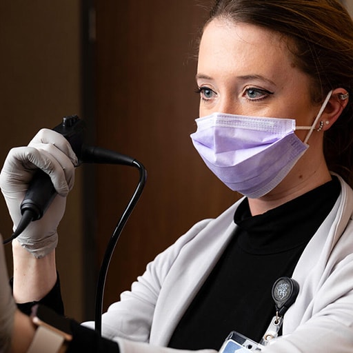 Speech Pathologist uses a laryngoscope to view a patient's larynx