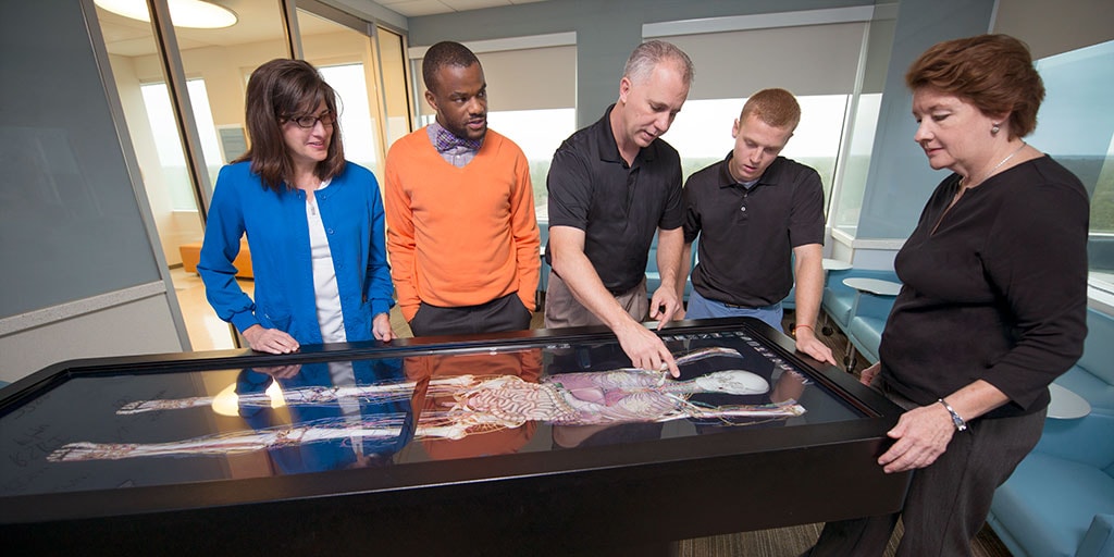 Faculty and students working with technology in the simulation center