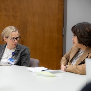 Physician and fellow speak during meeting