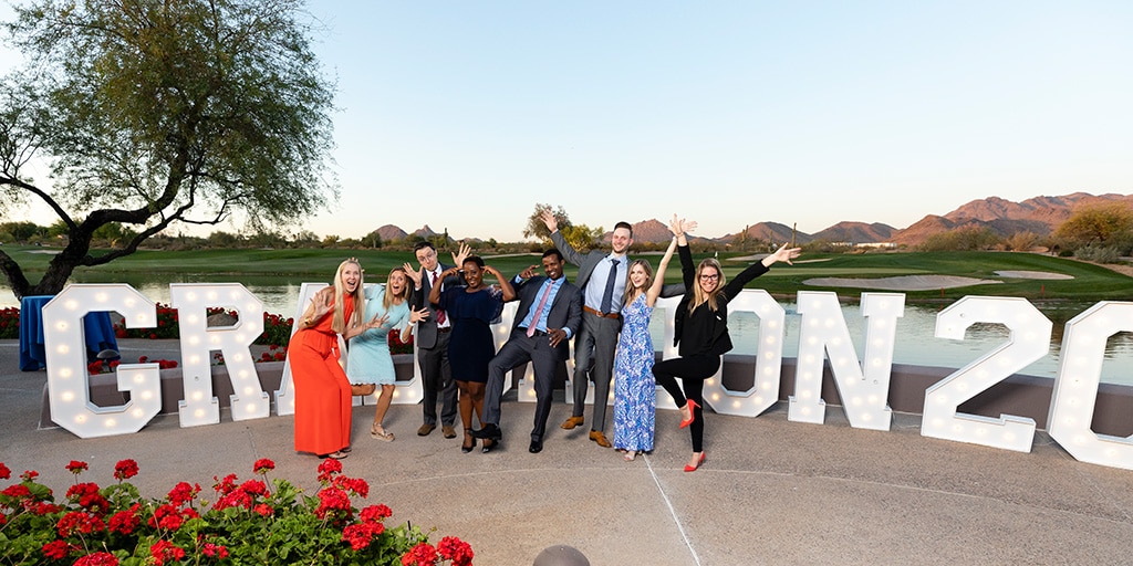 Eight residents from Mayo Clinic's Adult Neurology Residency in Arizona pose for a fun group photo in front of a life-size Graduation 2022 marquee sign.