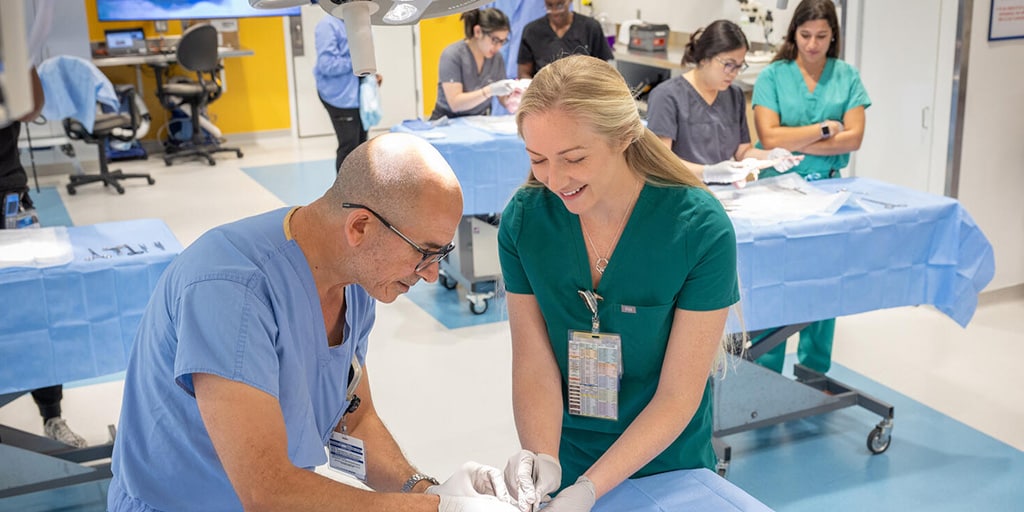 Two people from the Anesthesiology Residency program in Jacksonville, Florida, working in the lab and performing a procedure.