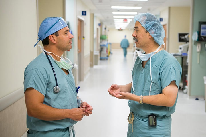 Two doctors from the Cardiology, Advanced Heart Failure and Transplant Cardiology Fellowship program at Mayo Clinic in Jacksonville, Florida, stand in a hospital hallway and have a discussion.