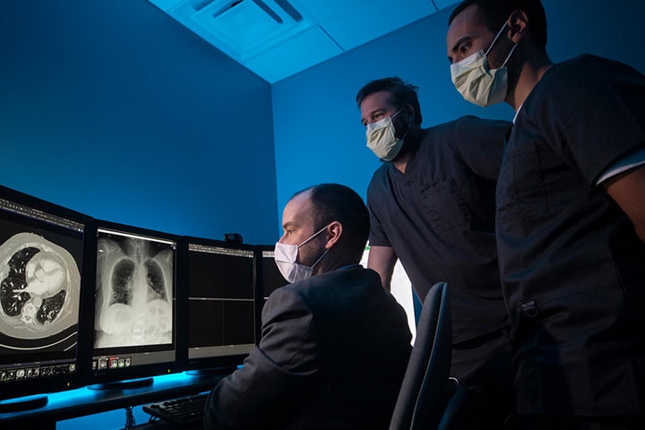 Cardiothoracic Imaging Fellowship in Jacksonville, Florida, three doctors review scans on monitors.