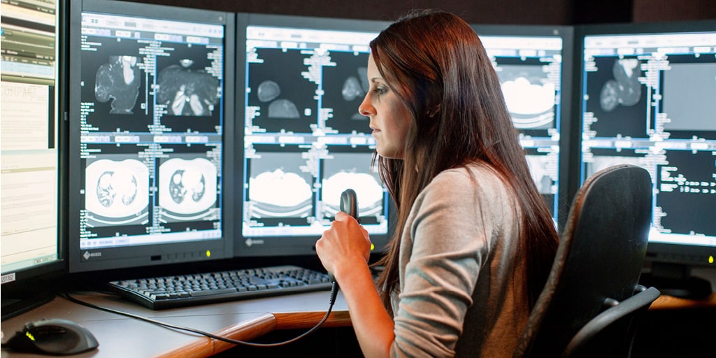 Mayo Clinic cardiothoracic radiologist fellow dictates into an audio recording device while reviewing an imaging scan on a computer monitor. 