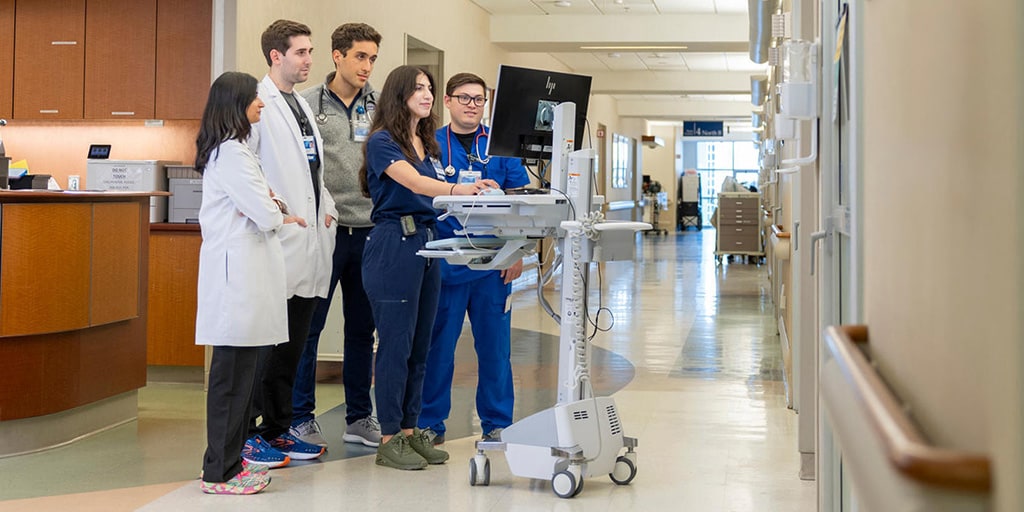 Five people from the Critical Care Medicine Fellowship program at Mayo Clinic in Jacksonville, Florida, had a discussion while looking at computer monitors in the hallway.