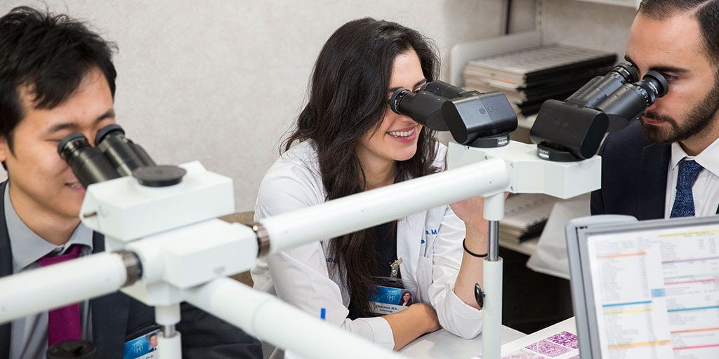Mayo Clinic dermatology residents in Arizona looking into microscopes