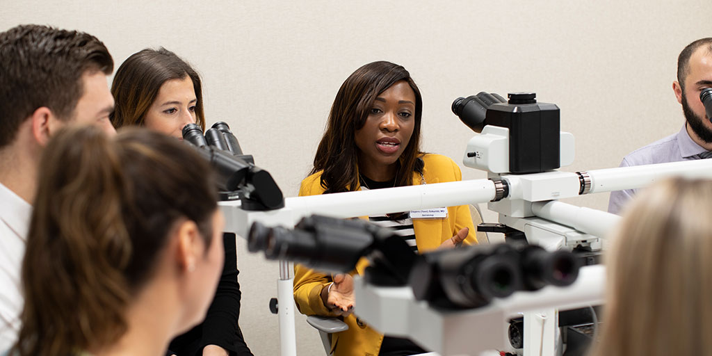 Dermatology trainees looking in a microscope
