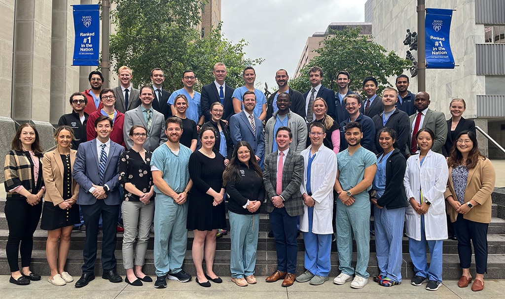 Thirty-six people dressed in business and medical attire from the Diagnostic Radiology Residency in Rochester, Minnesota, were outside standing on different levels of steps posing for a group photo.