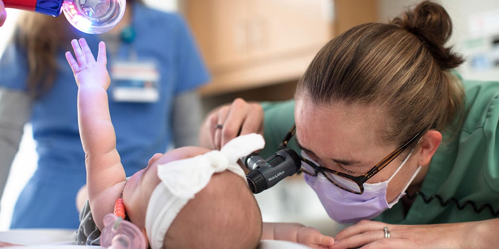 Emergency medicine resident examines a pediatric patient