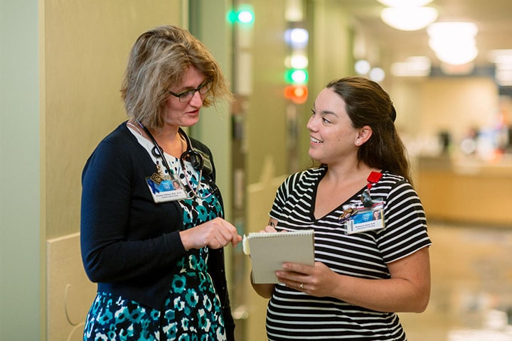 Endocrinology fellow speaks with a faculty member in the hallway at Mayo Clinic in Jacksonville, Florida.