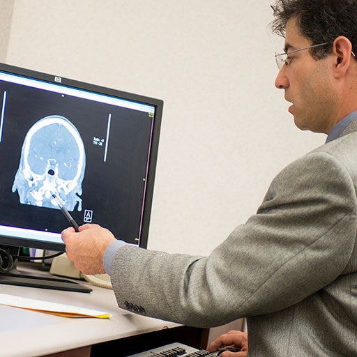 Program director of the Endovascular Surgical Neuroradiology Fellowship examines a scan