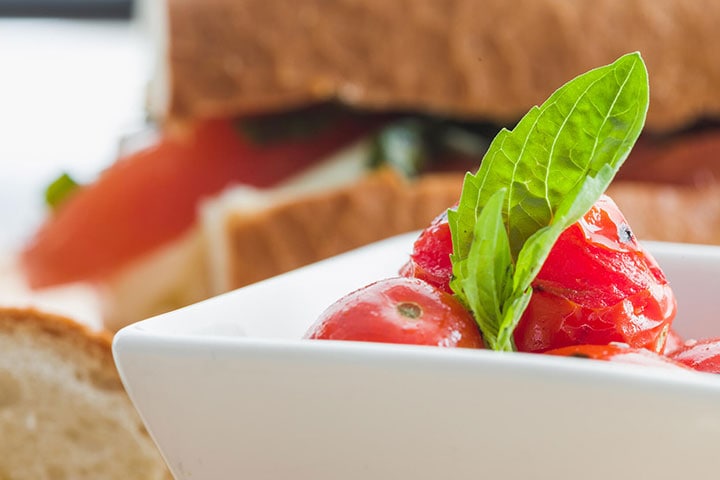 Roasted Cherry Tomato Salad, garnished with a basil leaf.