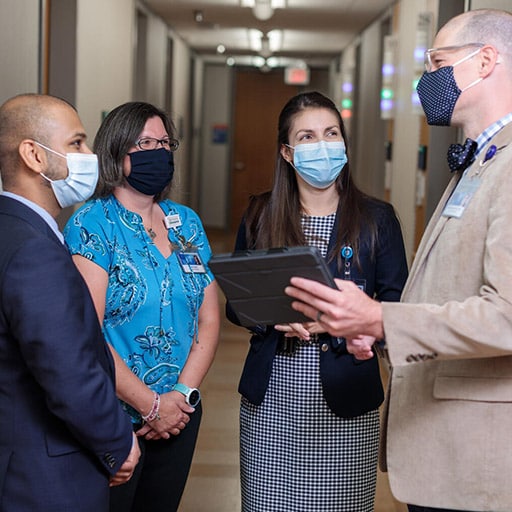 General Internal Medicine (GIM) staff have a stand up meeting in a hallway at Mayo Clinic in Rochester, Minnesota.