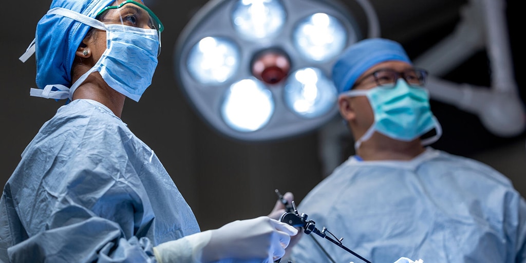 Two doctors work together during a procedure in an operating room.