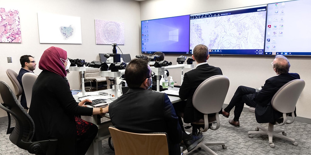 Mayo Clinic Genitourinary Pathology staff members look at pathology samples on multiple screens.