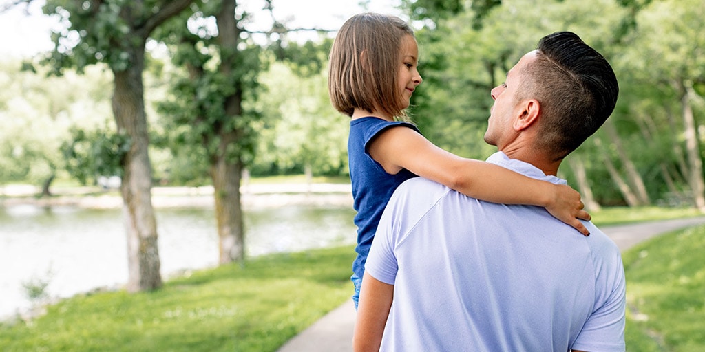 Trainee and daughter walking through a park in Rochester, Minnesota.